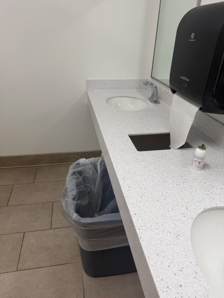 Clean restroom vanity counter with sinks and waste bin – Champion Facility Solutions